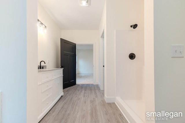 hall featuring light hardwood / wood-style flooring and sink