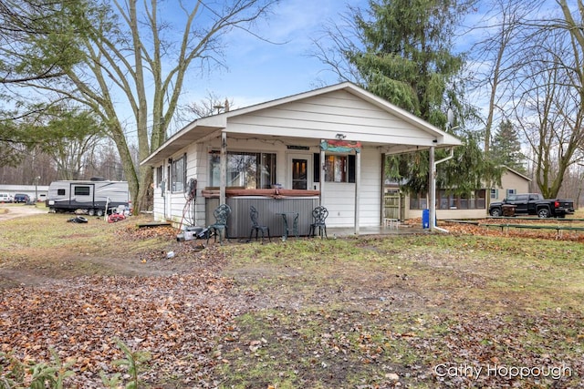 view of front of home featuring covered porch and a hot tub