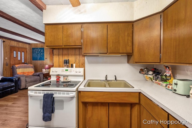 kitchen featuring electric stove, sink, wooden walls, hardwood / wood-style flooring, and beam ceiling