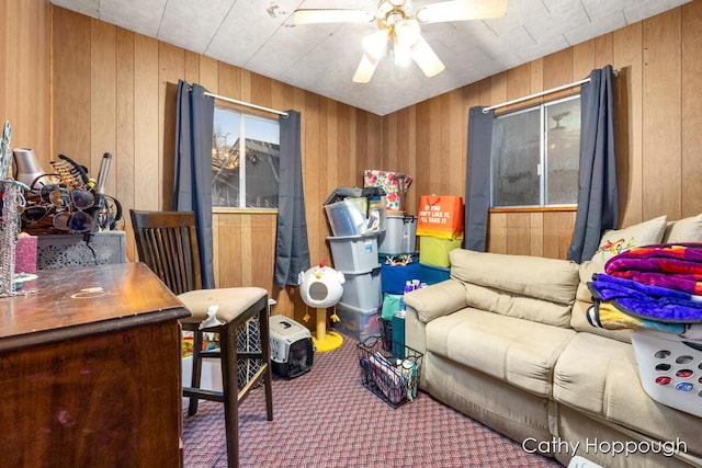 interior space with carpet flooring, wood walls, and ceiling fan