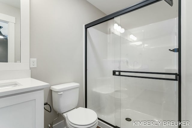 bathroom featuring vanity, an enclosed shower, and toilet