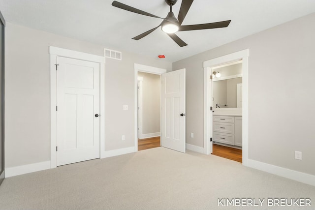 unfurnished bedroom with light carpet, ensuite bathroom, and ceiling fan