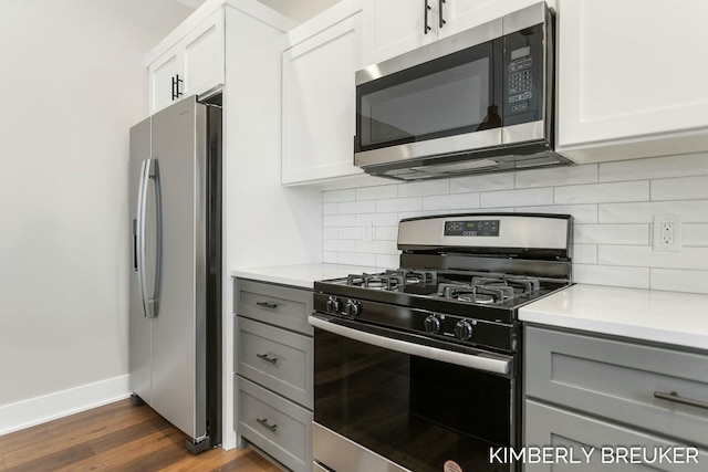 kitchen with decorative backsplash, dark hardwood / wood-style flooring, gray cabinetry, stainless steel appliances, and white cabinets