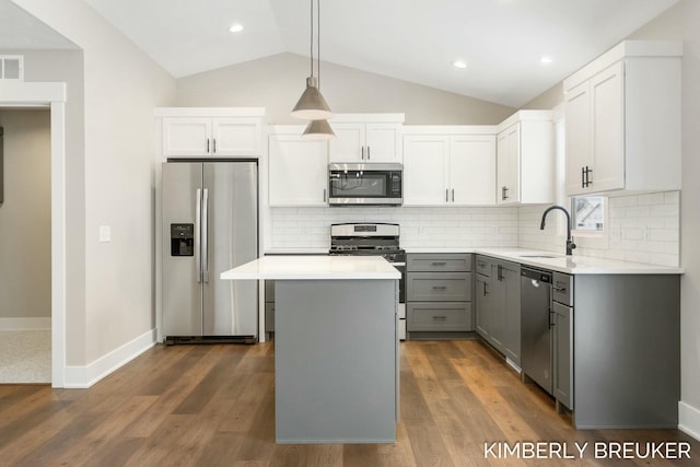 kitchen with gray cabinetry, stainless steel appliances, sink, a center island, and dark hardwood / wood-style floors