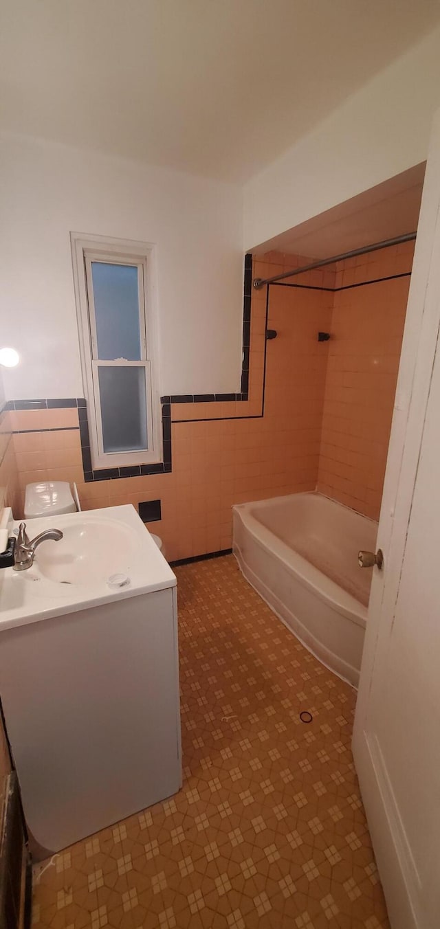 bathroom featuring vanity, tile walls, and tiled shower / bath