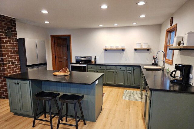 kitchen featuring a kitchen bar, stainless steel appliances, light hardwood / wood-style floors, and sink