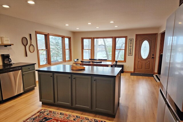 kitchen featuring gray cabinets, a center island, stainless steel appliances, and light wood-type flooring