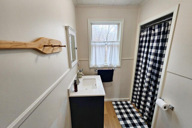 bathroom with a shower with curtain, vanity, wood-type flooring, and ornamental molding