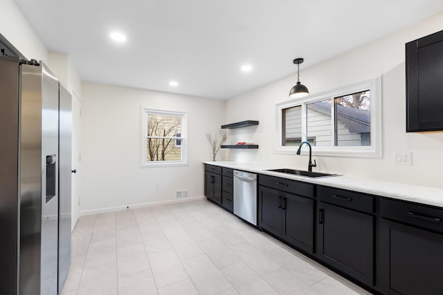 kitchen featuring stainless steel appliances, hanging light fixtures, and sink