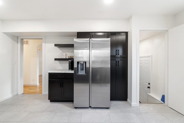 kitchen with stainless steel fridge with ice dispenser and light tile patterned floors