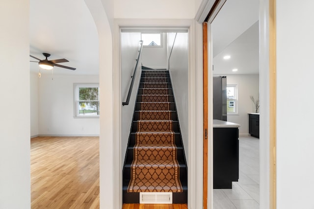 stairs featuring hardwood / wood-style floors and ceiling fan