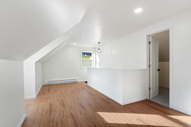 bonus room with lofted ceiling, light hardwood / wood-style flooring, and a baseboard heating unit