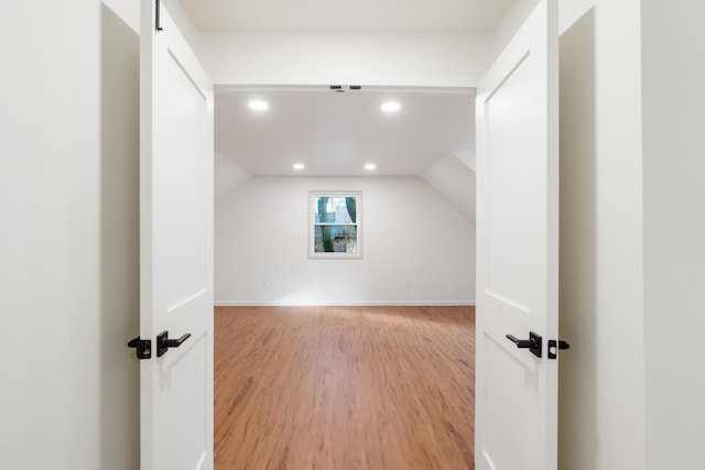 bonus room with light hardwood / wood-style floors and vaulted ceiling