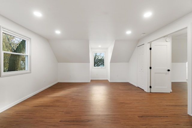 additional living space featuring hardwood / wood-style floors and vaulted ceiling