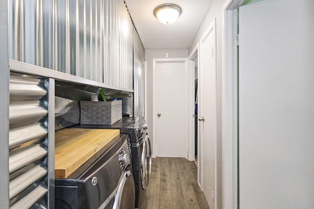 laundry area featuring hardwood / wood-style flooring and washing machine and dryer