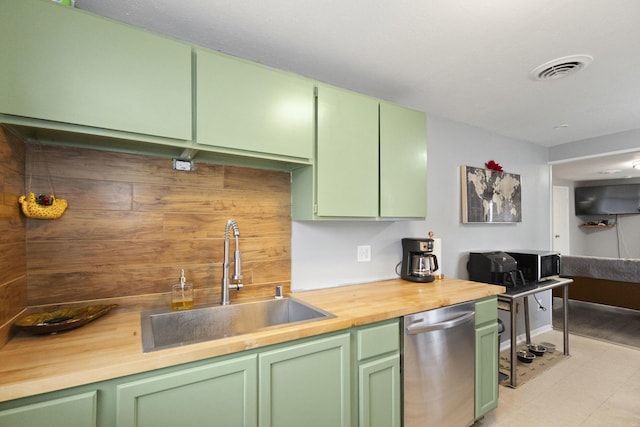 kitchen featuring sink, stainless steel dishwasher, butcher block countertops, and green cabinetry