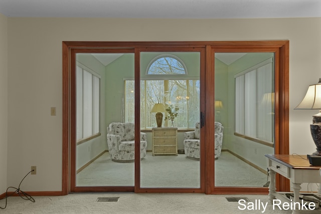 doorway featuring lofted ceiling and carpet