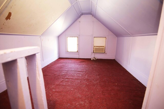 additional living space with carpet flooring, cooling unit, and lofted ceiling