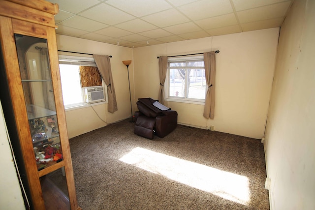 unfurnished room featuring carpet flooring, a drop ceiling, cooling unit, and a healthy amount of sunlight