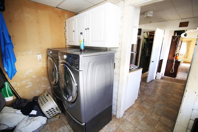 laundry area with washing machine and clothes dryer and cabinets