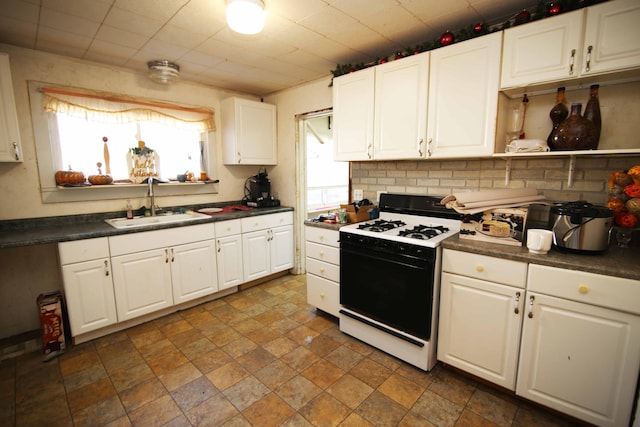 kitchen featuring decorative backsplash, white cabinetry, sink, and white range