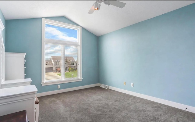 unfurnished bedroom with carpet, ceiling fan, vaulted ceiling, and multiple windows