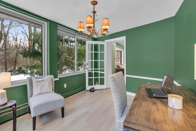 home office with a healthy amount of sunlight, an inviting chandelier, baseboard heating, and light hardwood / wood-style flooring