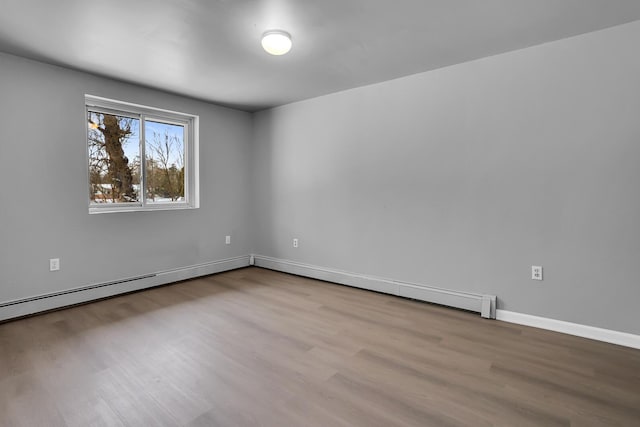 unfurnished room with light wood-type flooring and a baseboard heating unit