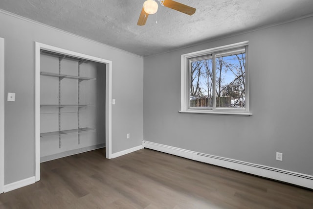 unfurnished bedroom featuring ceiling fan, a closet, dark hardwood / wood-style floors, and a baseboard heating unit