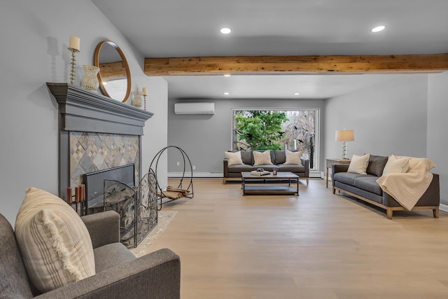 living room featuring a wall mounted air conditioner, light wood-type flooring, beamed ceiling, and a tiled fireplace