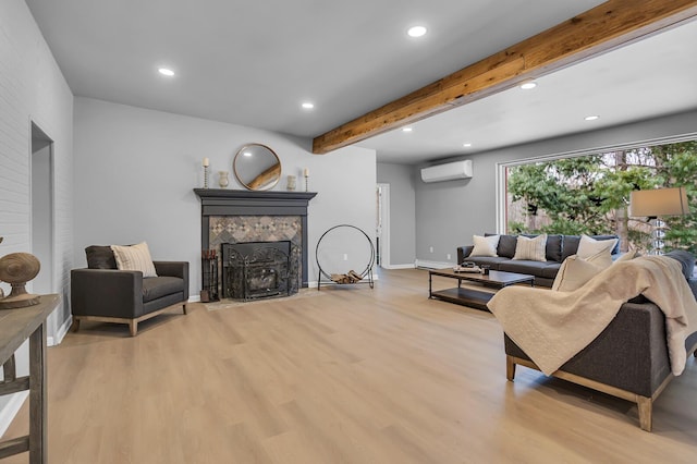 living room with a wall mounted AC, a baseboard radiator, light hardwood / wood-style flooring, beamed ceiling, and a fireplace