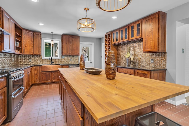 kitchen with high end stove, butcher block counters, tasteful backsplash, and a notable chandelier