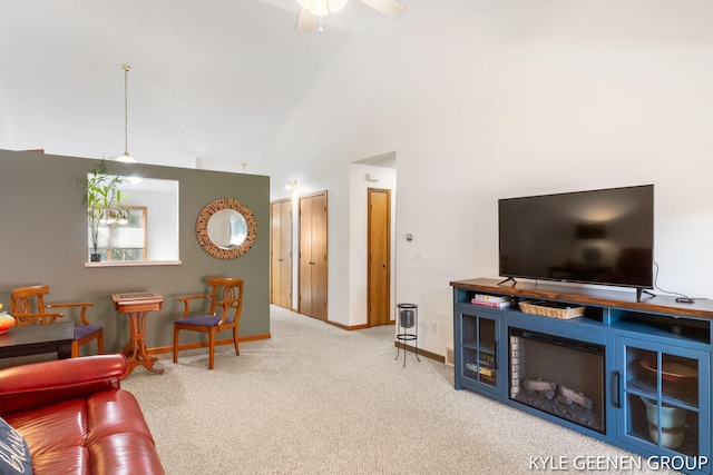 carpeted living room with ceiling fan and high vaulted ceiling