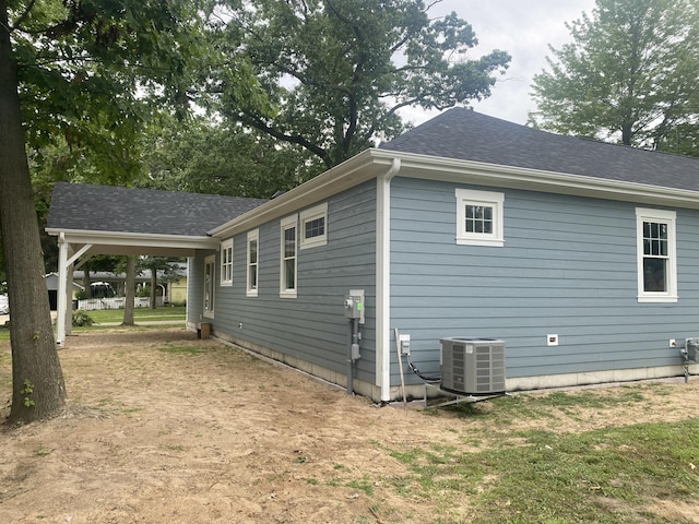 view of side of home with central air condition unit and a yard