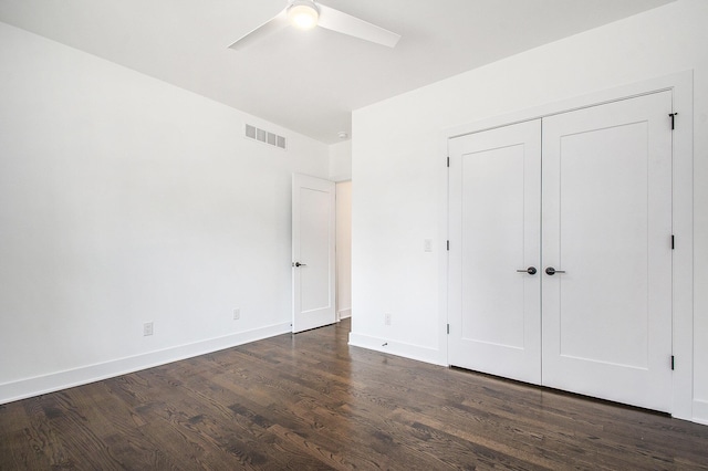 unfurnished bedroom with ceiling fan, a closet, and dark hardwood / wood-style floors