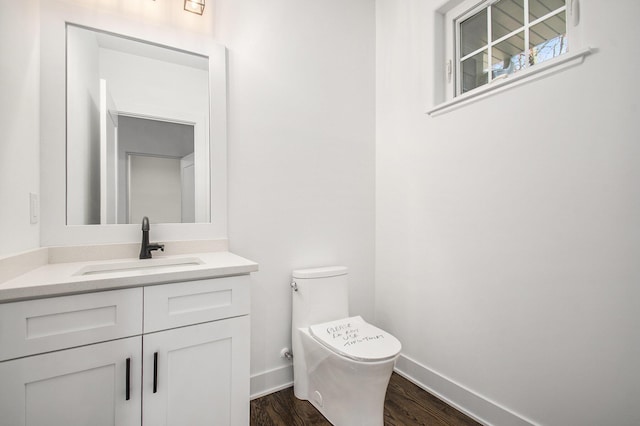 bathroom with hardwood / wood-style floors, vanity, and toilet