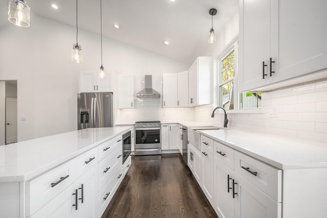 kitchen with pendant lighting, white cabinetry, wall chimney range hood, and stainless steel appliances