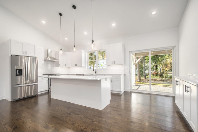 kitchen featuring white cabinets, a wealth of natural light, wall chimney exhaust hood, and appliances with stainless steel finishes