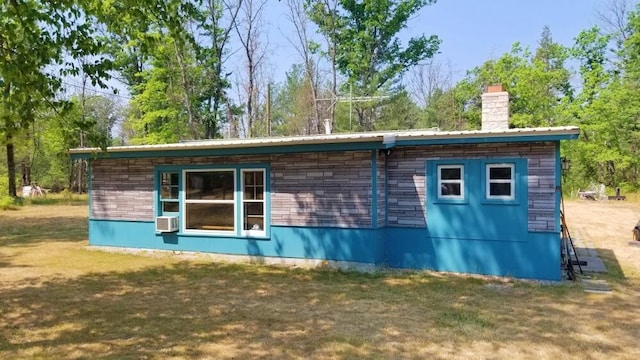 view of side of property featuring cooling unit and a lawn