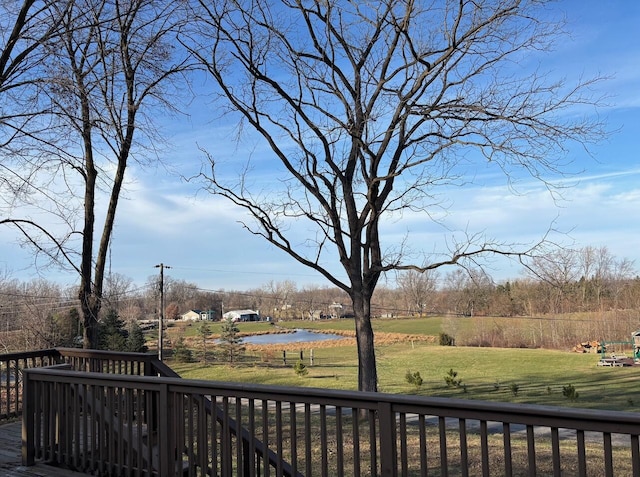 wooden deck with a lawn and a water view