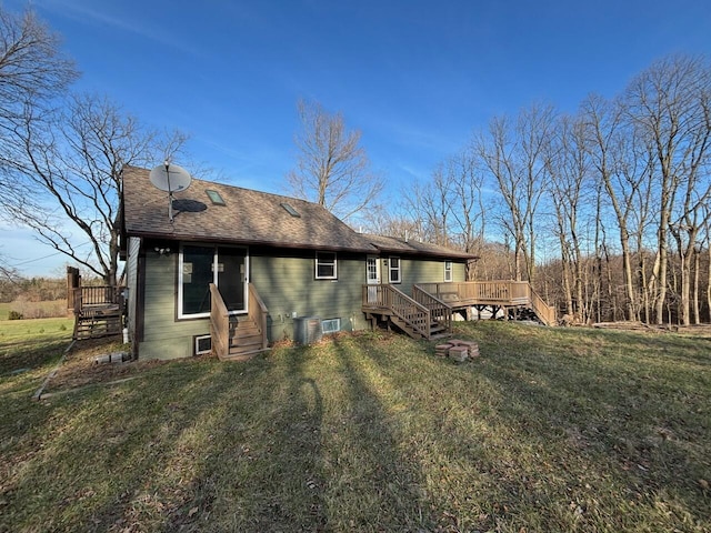 rear view of house featuring a lawn and a deck