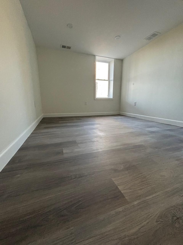 unfurnished room featuring dark wood-type flooring