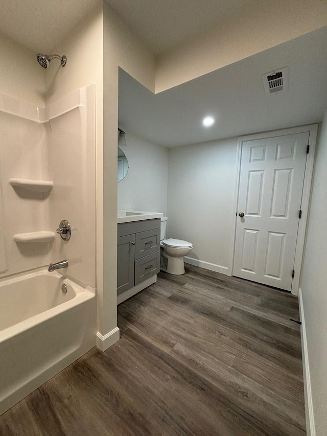 full bathroom featuring hardwood / wood-style floors, vanity, toilet, and shower / tub combination