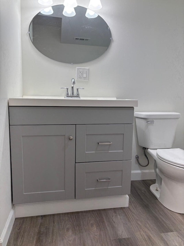 bathroom featuring vanity, wood-type flooring, and toilet