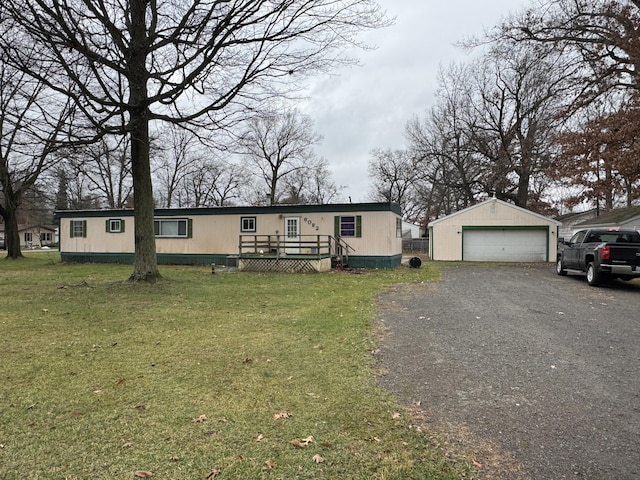 manufactured / mobile home with a wooden deck, a front lawn, an outdoor structure, and a garage