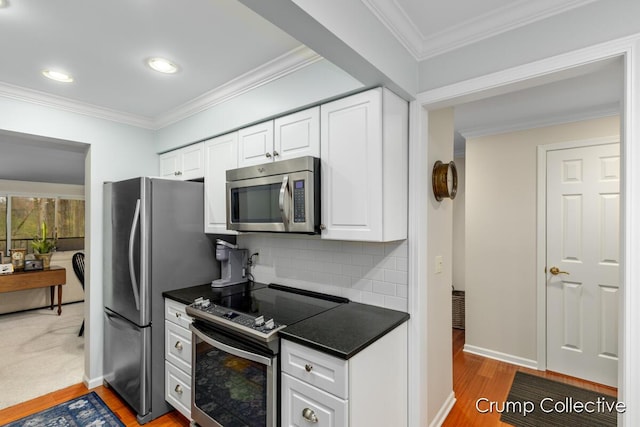 kitchen featuring backsplash, stainless steel appliances, crown molding, light hardwood / wood-style floors, and white cabinetry