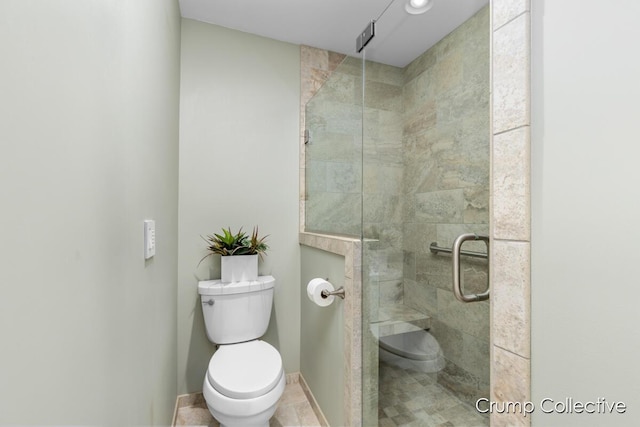 bathroom with tile patterned flooring, toilet, and walk in shower