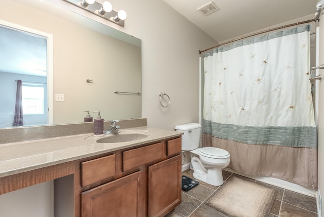 bathroom featuring tile patterned floors, vanity, toilet, and walk in shower