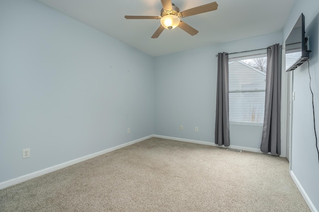 unfurnished room with light colored carpet and ceiling fan