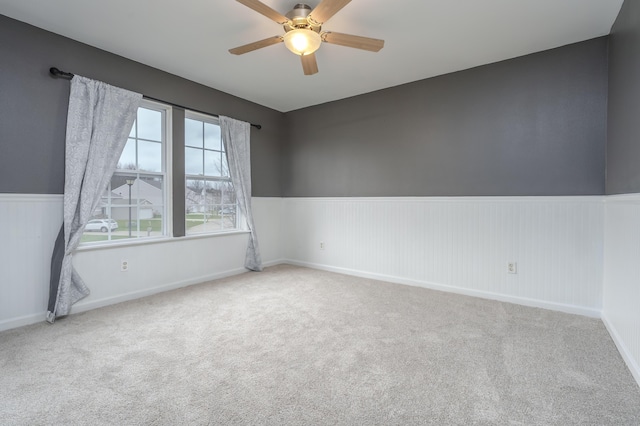 carpeted spare room featuring ceiling fan